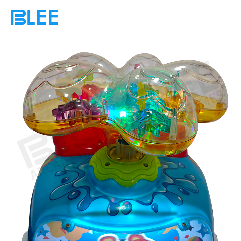 Child gently rocking on the whale ride, holding the secure dorsal fin handles