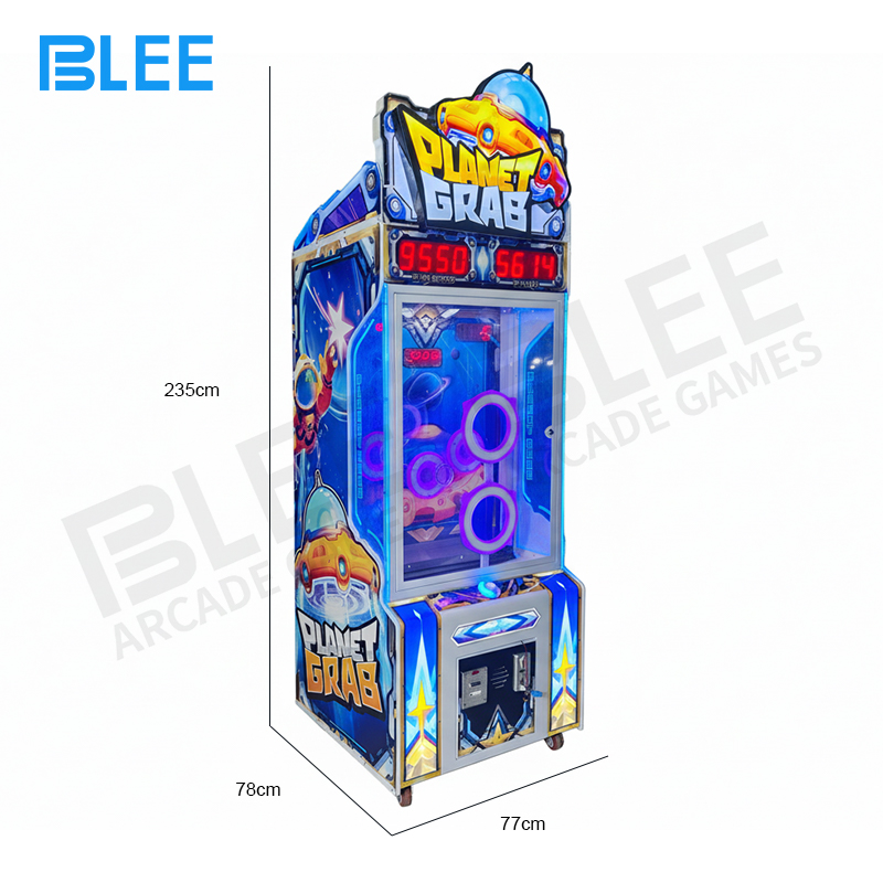 A player's hand reaching into the machine to catch a colorful ball from the interior pool.