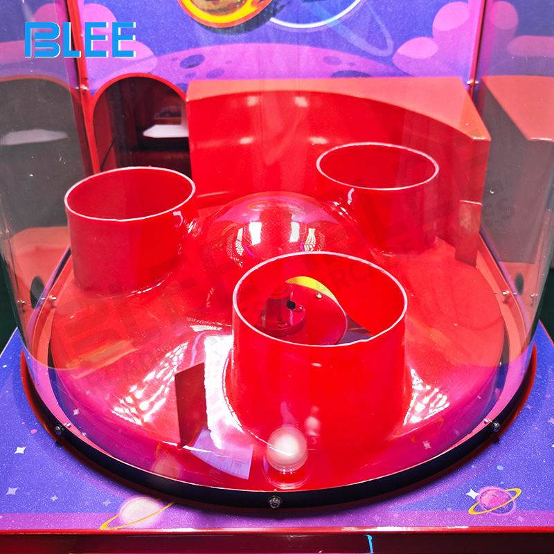 Close-up of colorful balls navigating intricate chutes and bumpers inside transparent tower