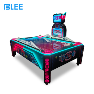 Player inserting coins to activate gameplay on the multi-ball air hockey table.