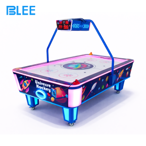 Player inserting coins to activate gameplay on the ticket redemption air hockey table.