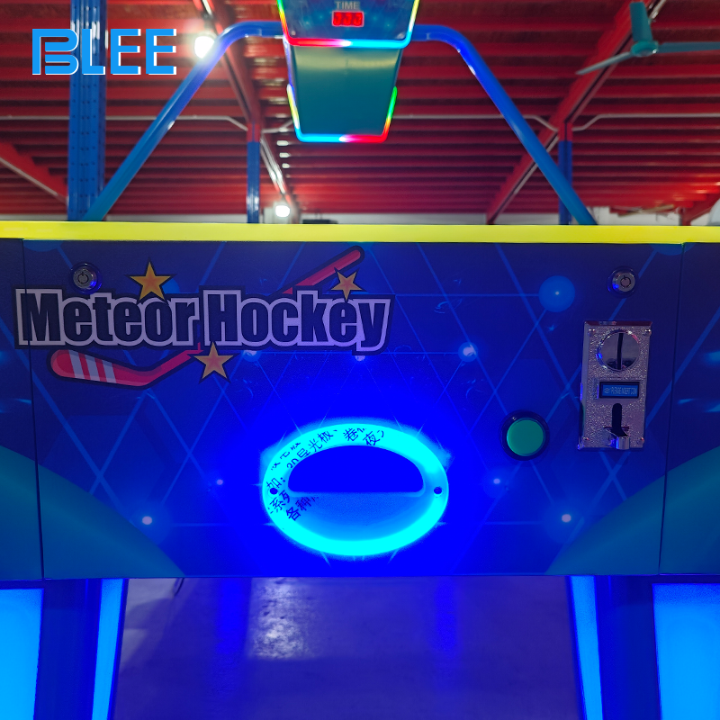 Player inserting coins to activate gameplay on the ticket redemption air hockey table.
