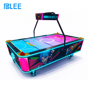 Player inserting coins to activate gameplay on the ticket redemption air hockey table.