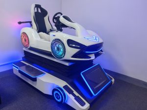 Player seated in the premium Porsche-style cockpit wearing the Dapeng E3S headset during a high-speed circuit race.