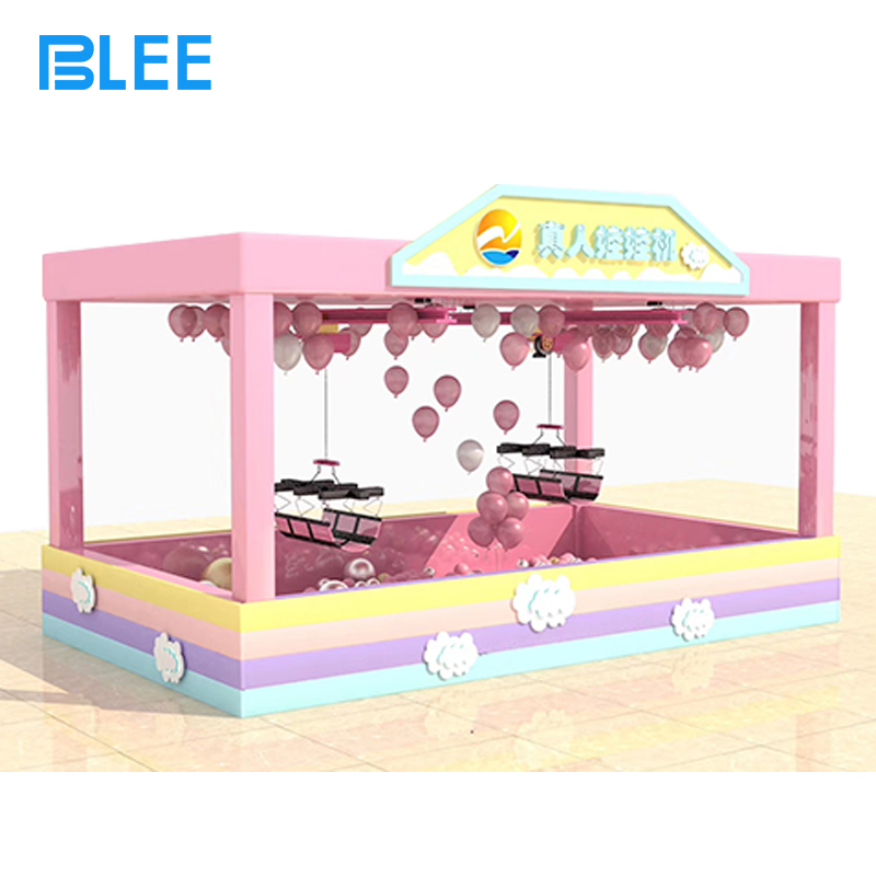 giant prize machine Player strapped into the harness being lifted above a sea of plush toys and colorful gifts.